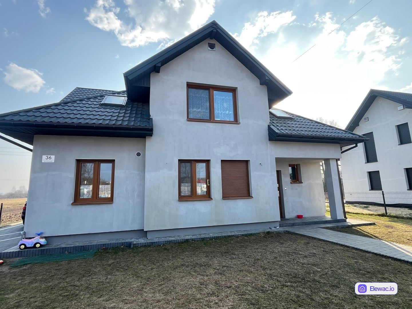 Dom jednorodzinny z lat 2000. z szarym tynkiem przed remontem elewacji